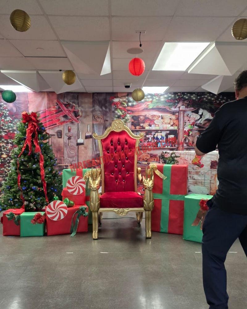 Santa photos in Port St. Lucie: gold chair among gift boxes, a lit tree, and a workshop backdrop.